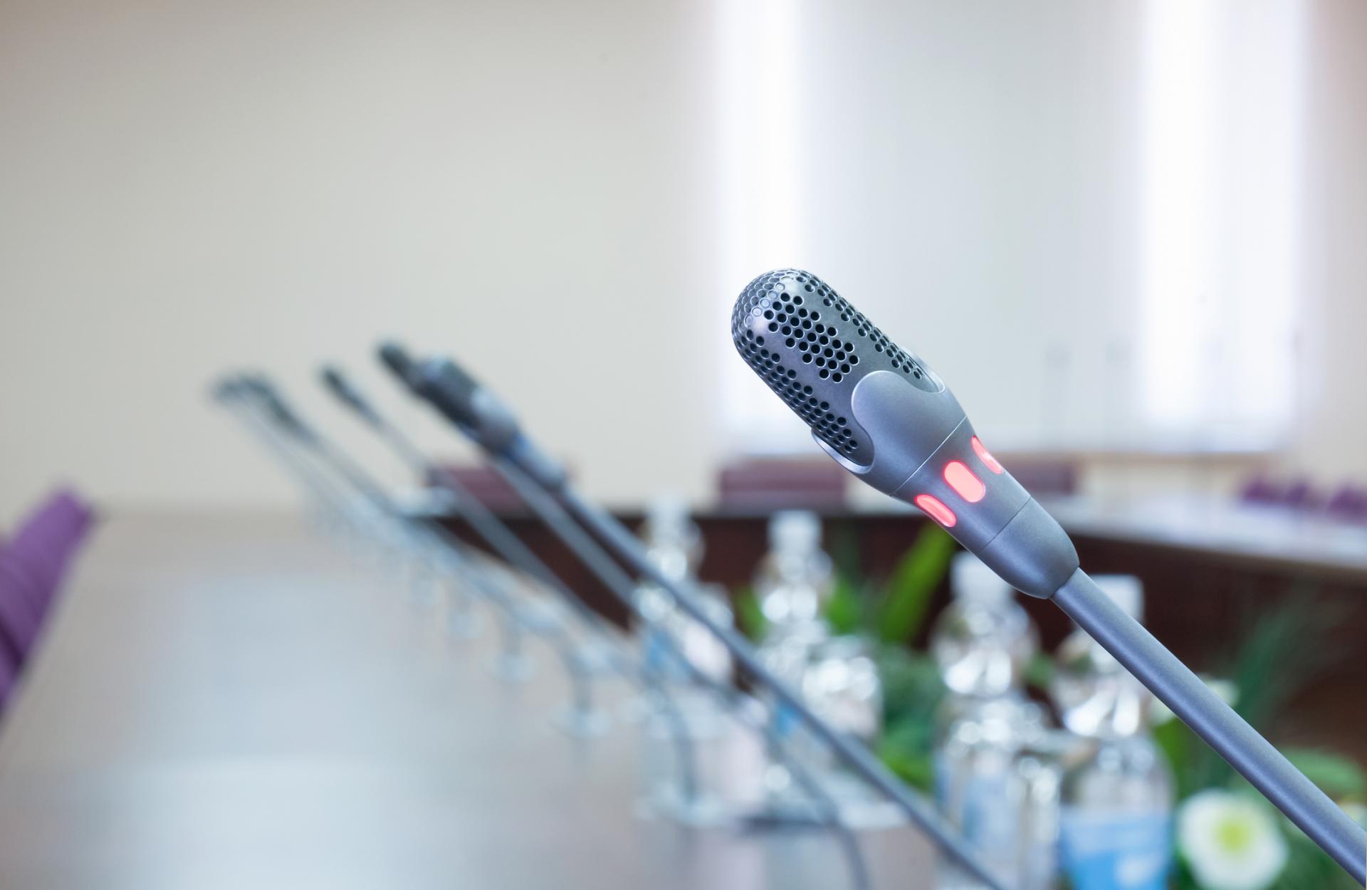 The images shows multiple microphones installed within a long table