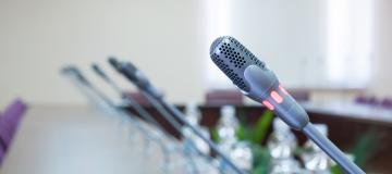 The images shows multiple microphones installed within a long table